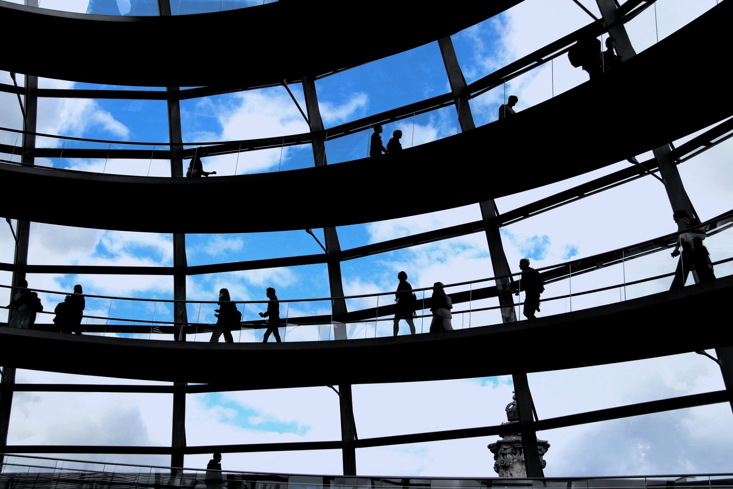 People walking through a modern glass atrium