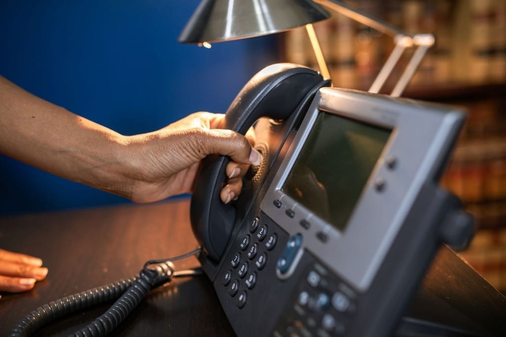 Hand reaching for an office telephone